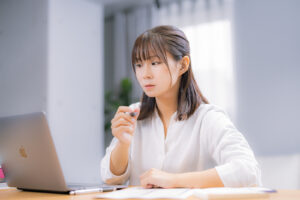 パソコンを使って調べる女性
